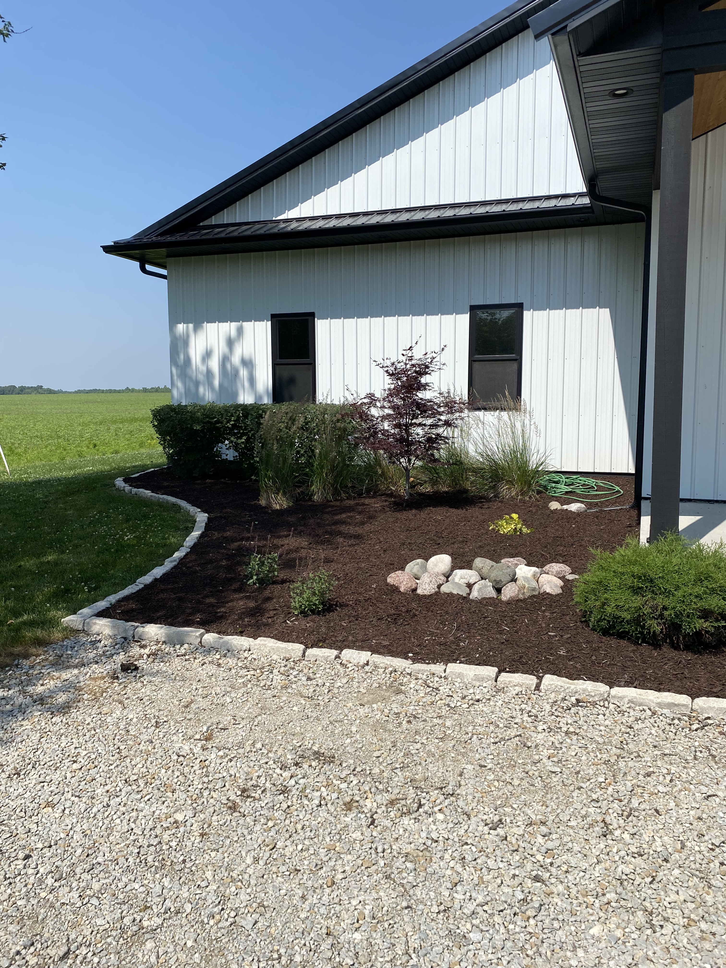 Freshly landscaped bed with shrubs beside a white building