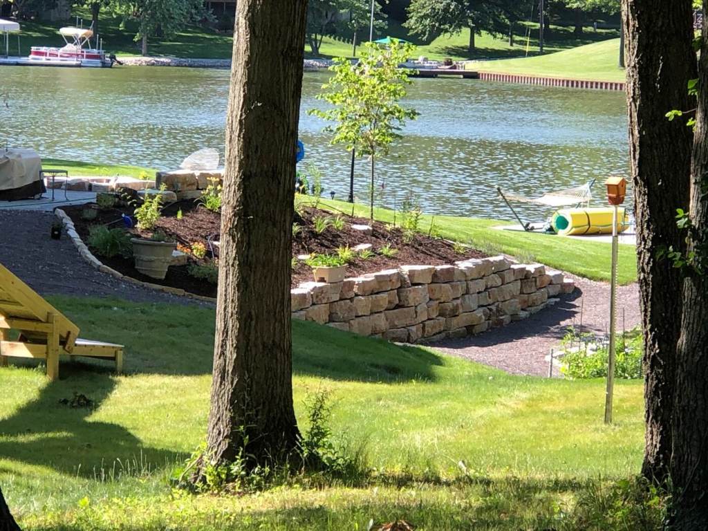 Natural stone retaining wall and landscaped planting bed overlooking a lake